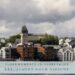 Blick auf Ålesund mit historischen Gebäuden und Kirche am Wasser, unter dramatischem Himmel – Titelbild zur Kreuzfahrt durch Norwegen