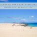 Weite Sanddünen und türkisblaues Meer auf Fuerteventura mit Covertext: Strände auf Fuerteventura – perfekt für deine Winterflucht