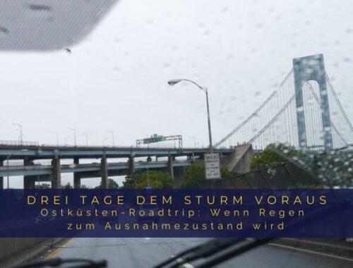 Blick durch die regennasse Windschutzscheibe mit Scheibenwischern auf eine Brücke während eines Roadtrips an der US-Ostküste im Sturm.